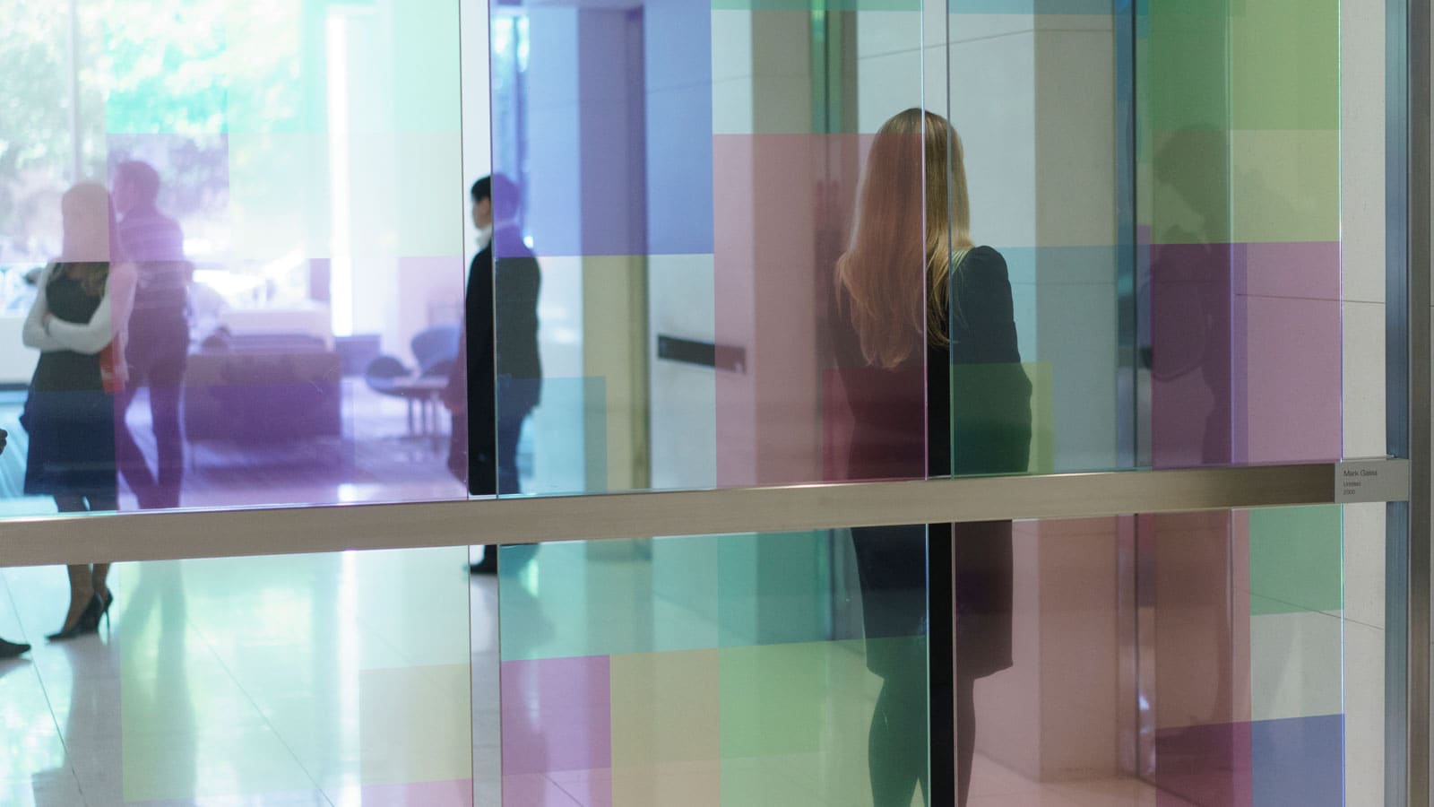 Lady walking behind coloured glass