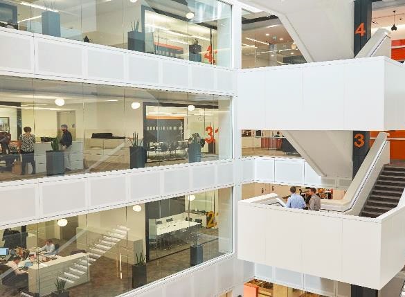 White stair case inside a building with people walking down