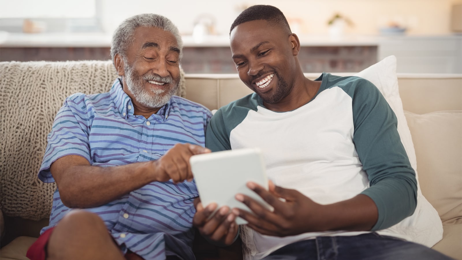 A man and his son sitting on a couch.