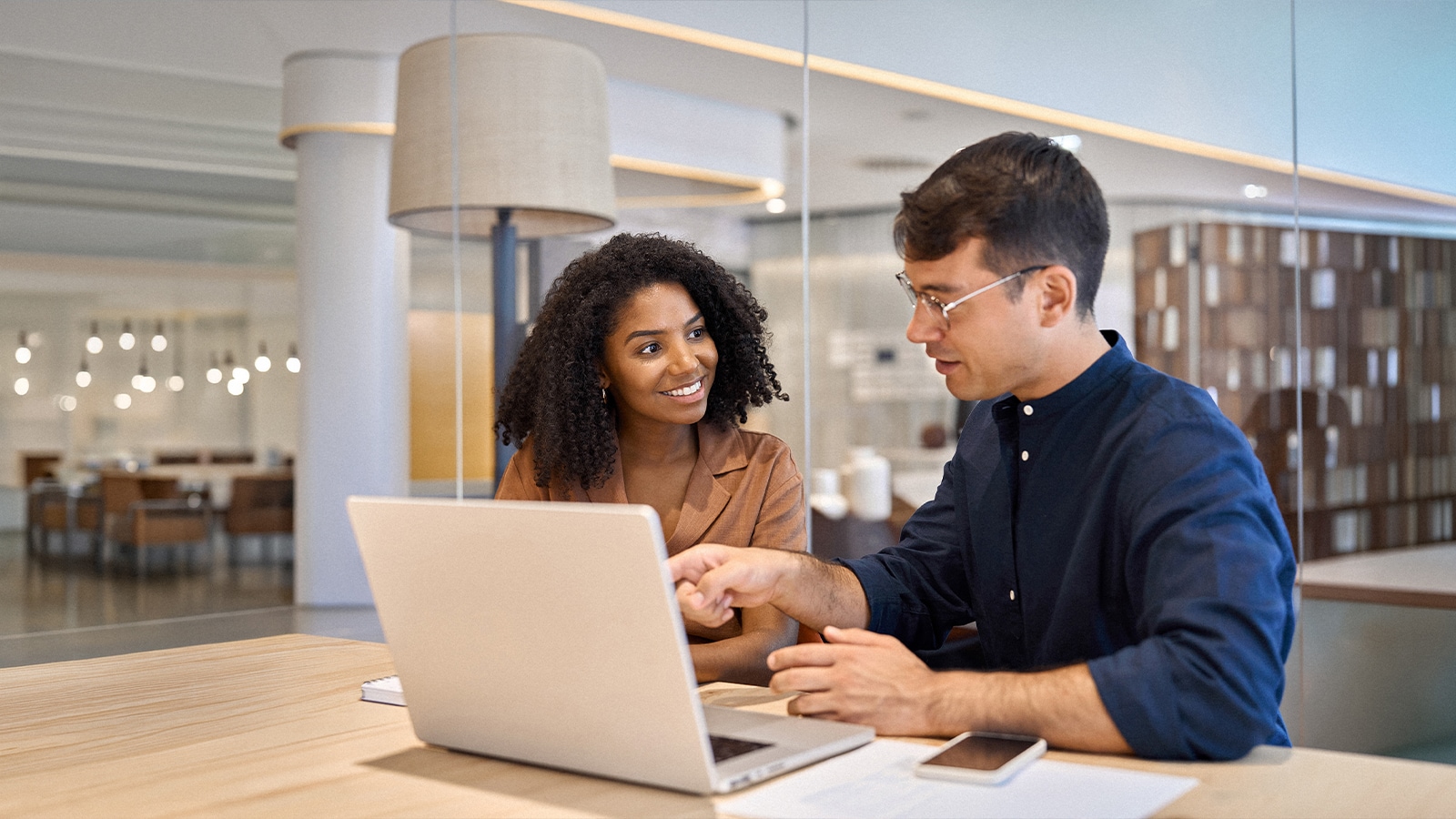 Image of two people sitting at a tablet.