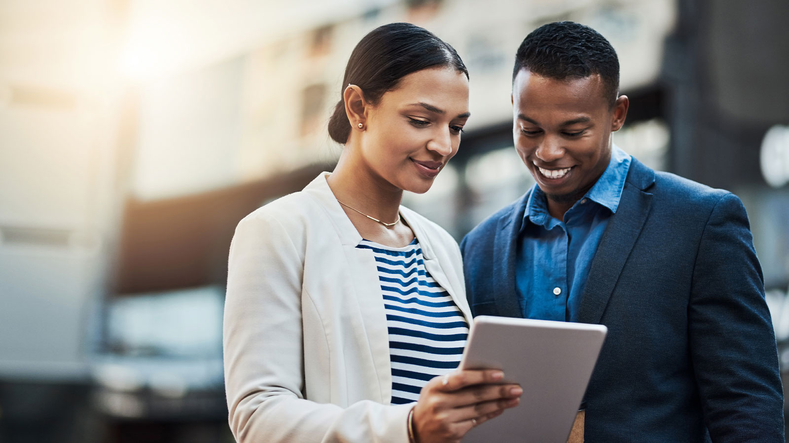 Two people reading about the taxing times survey on a tablet.