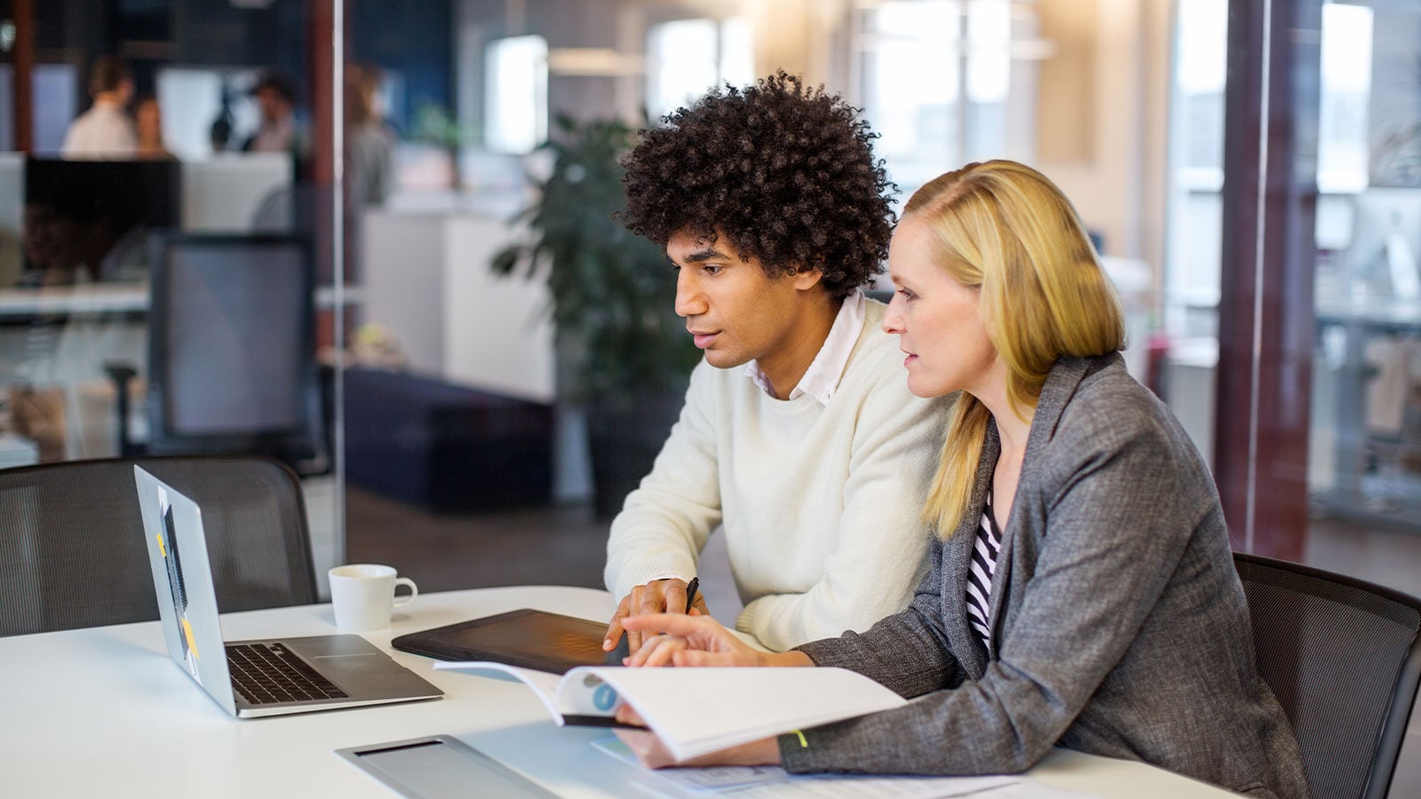 Two people looking at PwC's Performance plus product.