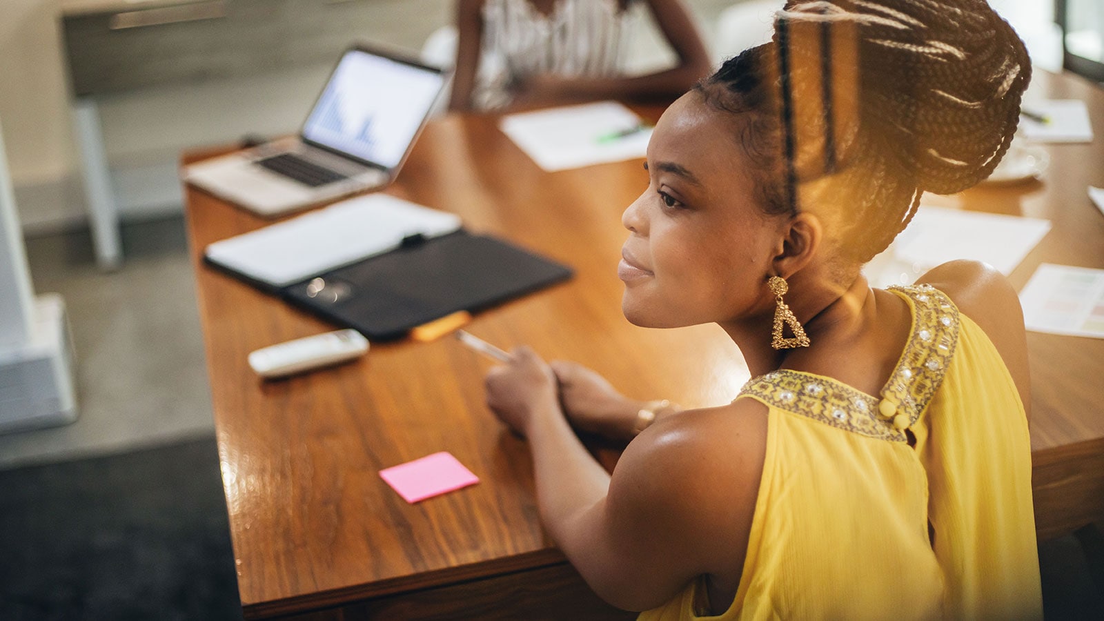Woman sitting in a boardroom.