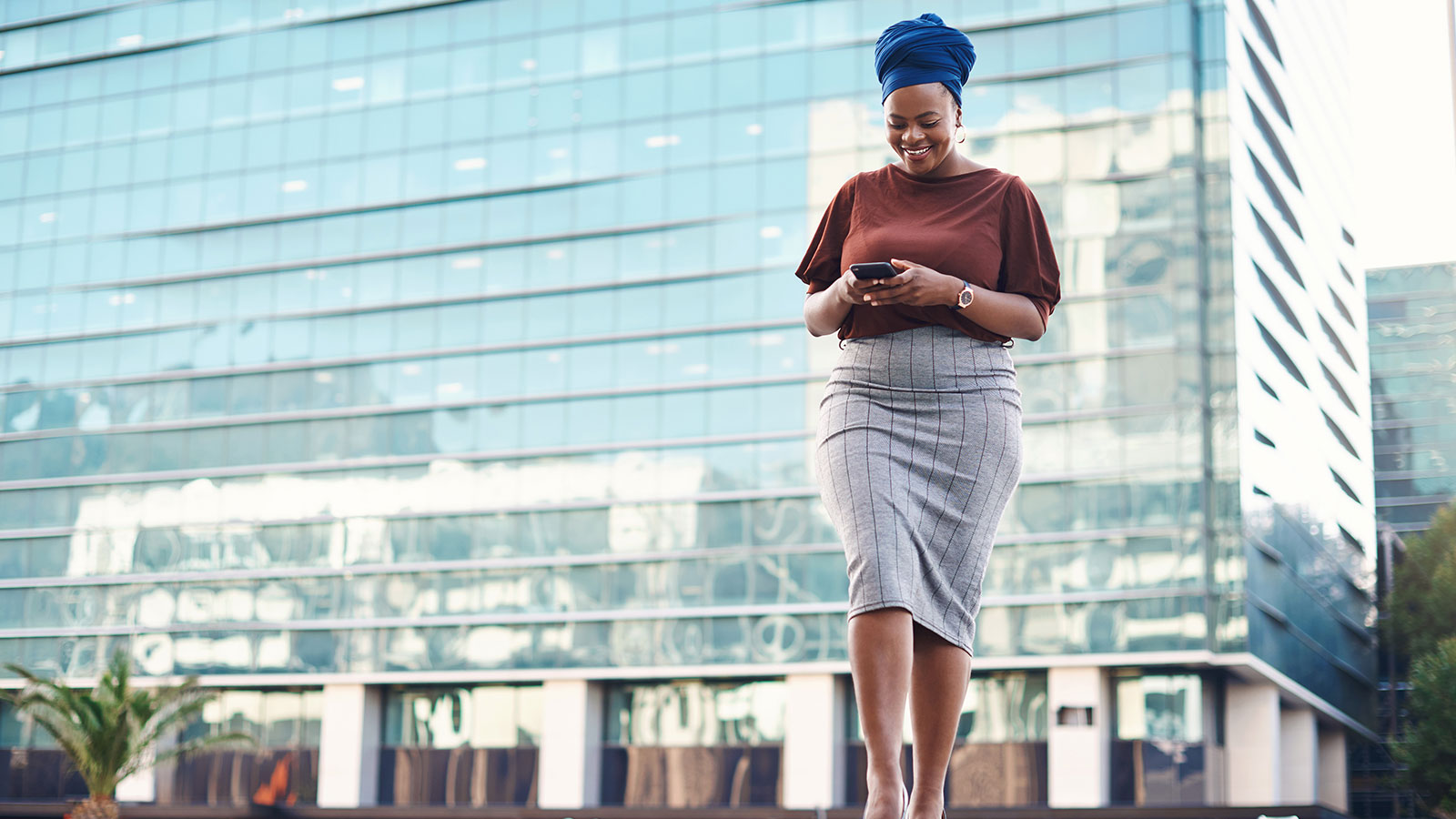 Woman reading about PwC on her cellphone.