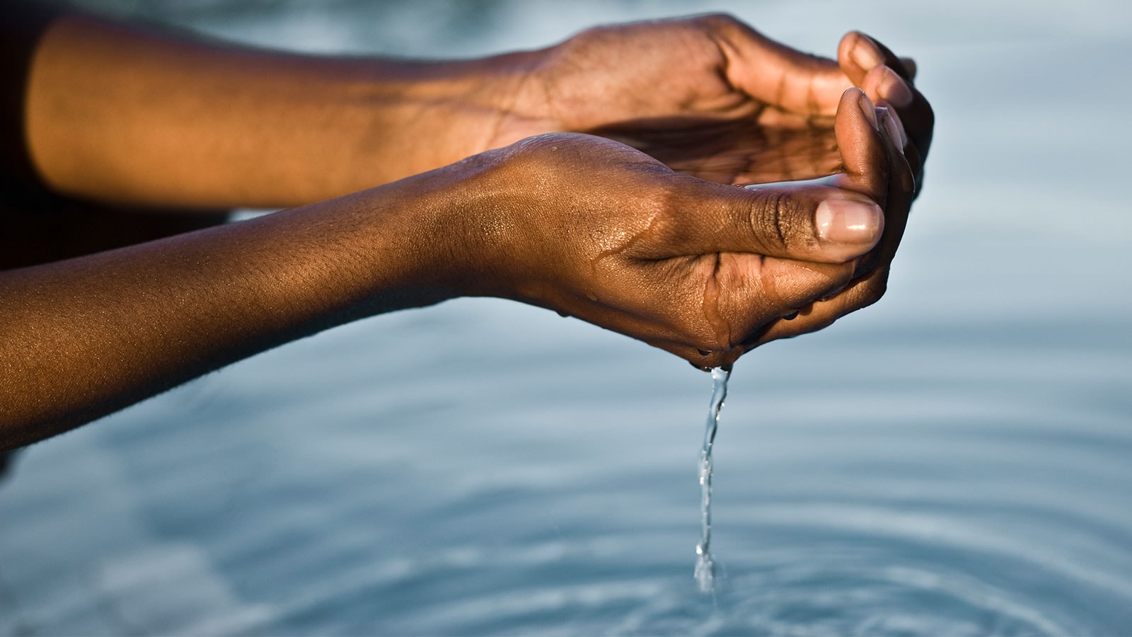 Women with hands full of water.