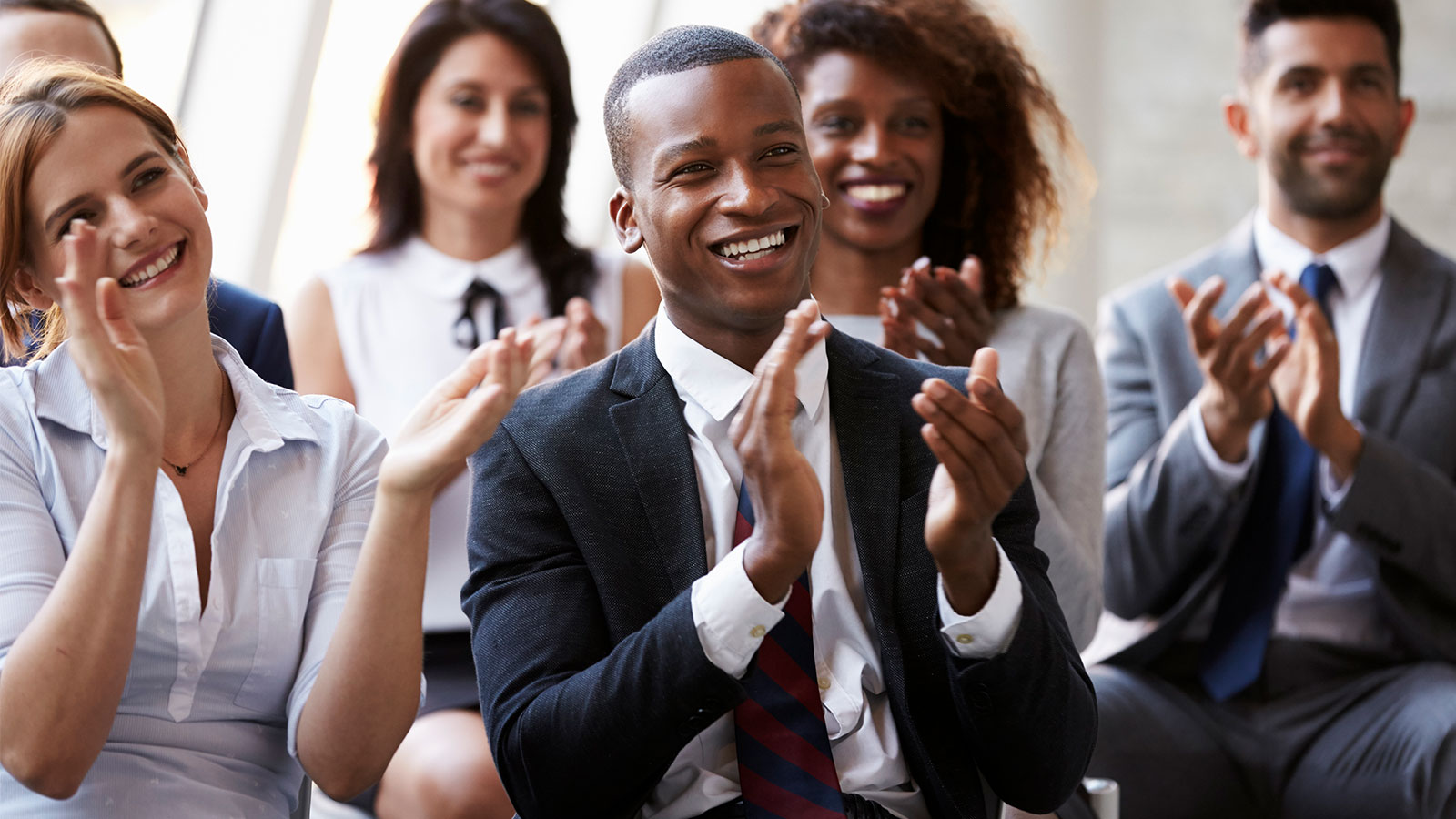 Image of a group of people clapping hands.