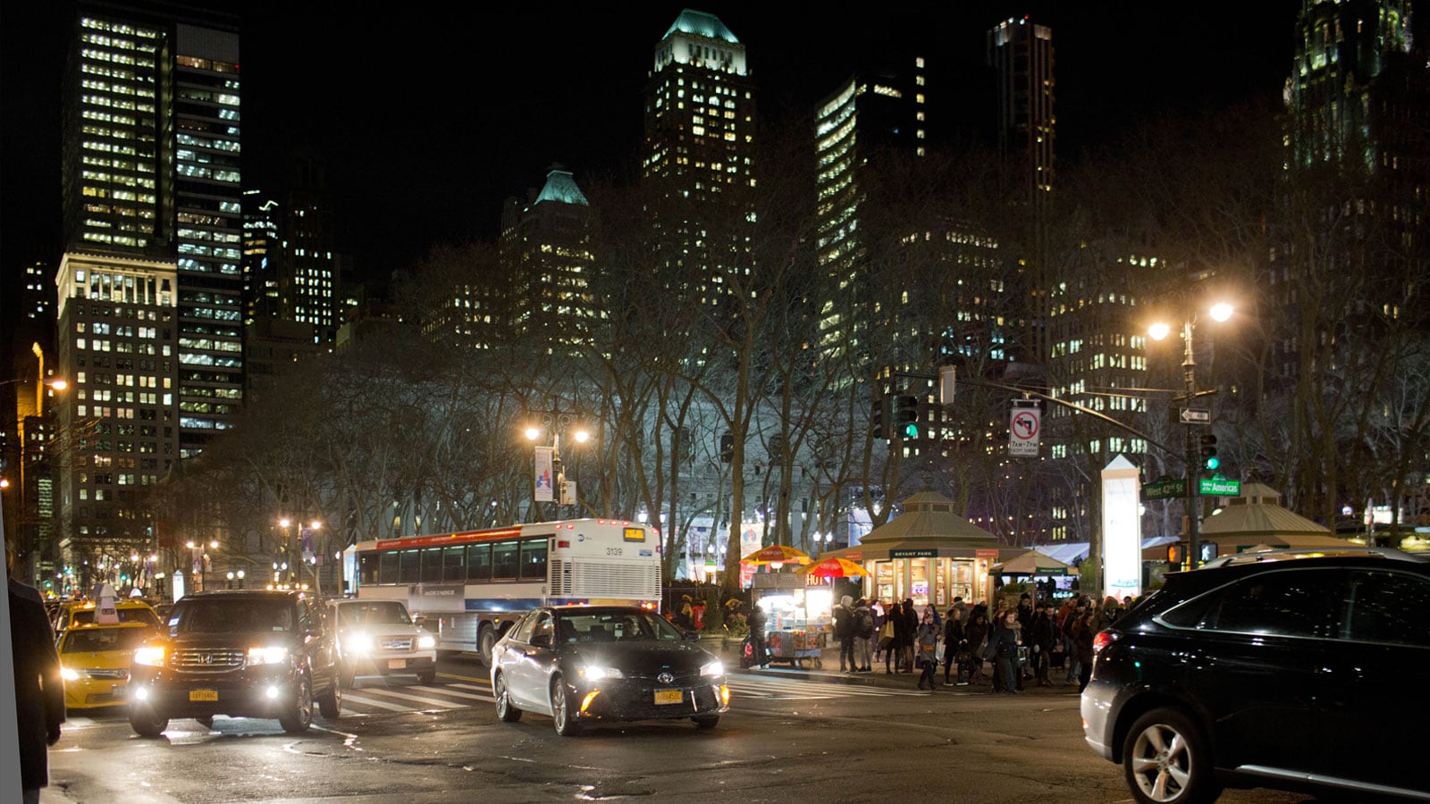 overview of city buildings  and cars in the street at night