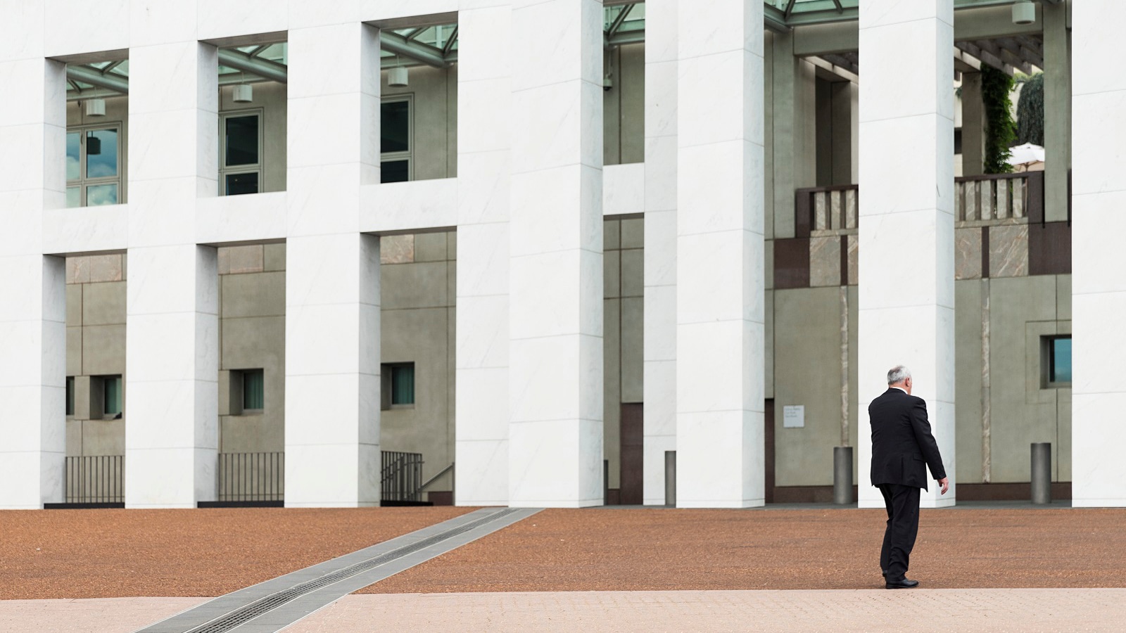 male professional walking towards a building