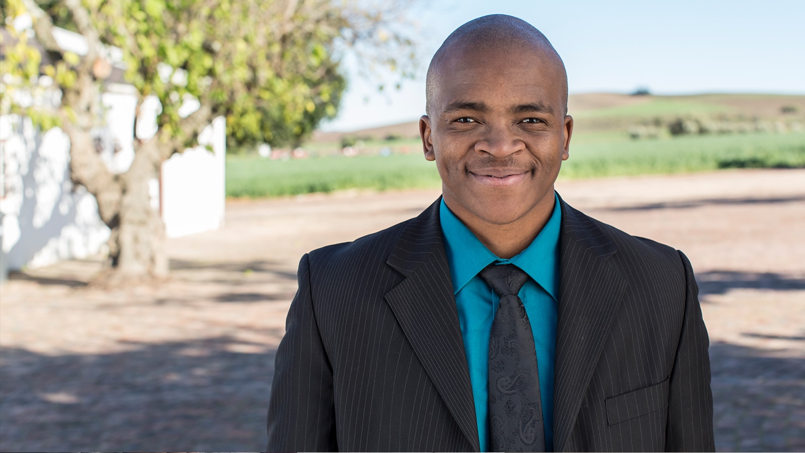 Man in blue shirt and jacket smiling