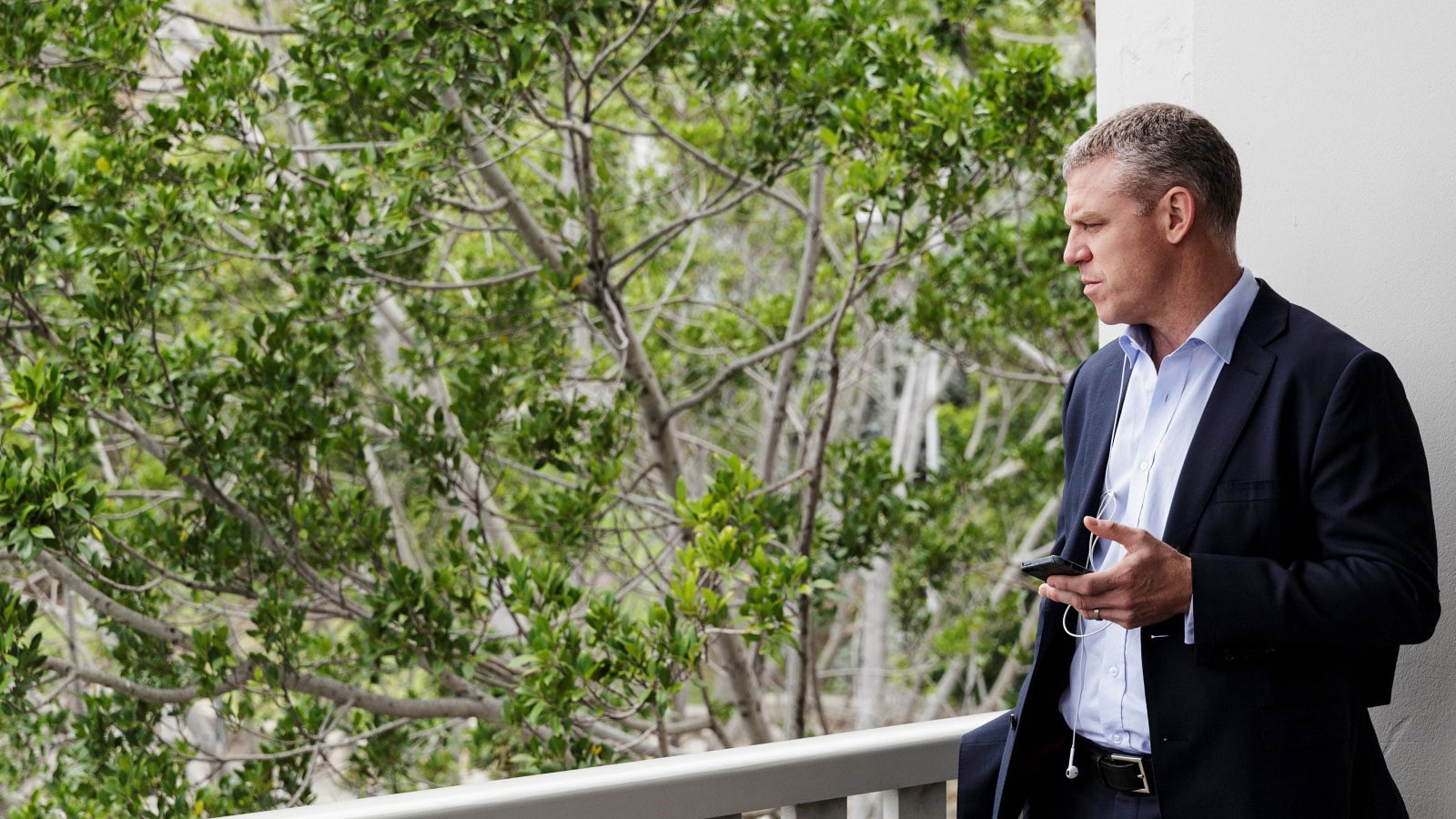 Business man standing with his phone in his hand