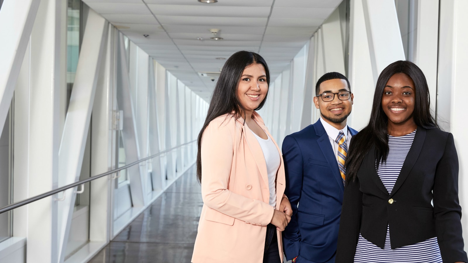 Three PwC PCS employees standing together