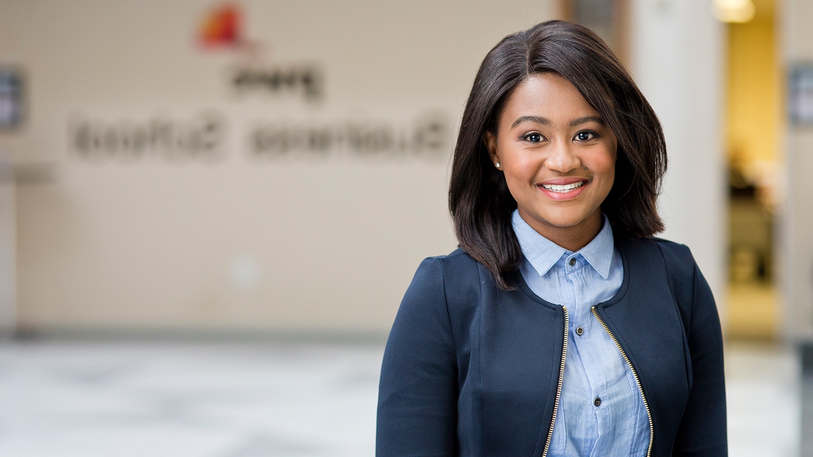 Young female in navy blue blazer smiling